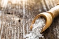 Sea salt in a spoon on wooden table.