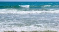 Sea salty pure blue waves roll on the sand of the local beach. Royalty Free Stock Photo