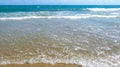 Sea salty pure blue waves roll on the sand of the local beach. Royalty Free Stock Photo