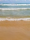 Sea salty pure blue waves roll on the sand of the local beach. Royalty Free Stock Photo