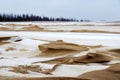 Sea sand with white snow, gray sky