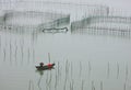 The Small boat shuttling between the sea fish farms Royalty Free Stock Photo