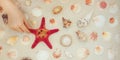 Sea shells and red star fish on sandy beach with copy space for text Royalty Free Stock Photo