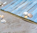 Sea shells, sand and blue wooden plank, copy space Royalty Free Stock Photo