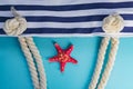 Sea shells, starfish and textile stiped navy bag with rope knots on light blue background. summer holiday and vacation concept Royalty Free Stock Photo