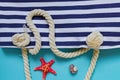 Sea shells, starfish and textile stiped navy bag with rope knots on light blue background. summer holiday and vacation concept Royalty Free Stock Photo