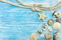 Sea shells, stones, star fish and rope on blue wooden background Royalty Free Stock Photo