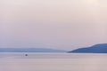 Sea ship moves towards Cres Island at sunset on Adriatic Sea. Royalty Free Stock Photo