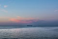 Sea ship under pink cloud - sunrise / sunset