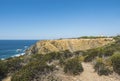 Sea shore and cliff with red and white historic Portugese lighthouse Cabo Sardao building on Ponta do Cavaleiro, Rota