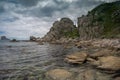 Sea shore with large stones on a background of cloudy sky and flying gulls Royalty Free Stock Photo