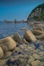 Sea shore with transparent water and stones at the bottom.