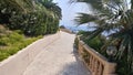 Sea shore view with boardwalking path the palm trees Royalty Free Stock Photo