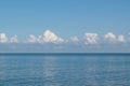 Blue sky and blue sea, white clouds. Beautiful seascape on a sunny day Royalty Free Stock Photo