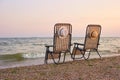 Sea, sky, beach with beach chairs on morining, back view.