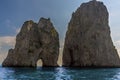 Sea Stacks and a natural arch of the Faraglioni rocks silhouetted against the early morning sunshine on the eastern side of the Royalty Free Stock Photo