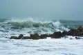 Sea storm waves dramatically crashing and splashing against rocks