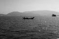 Sea, mountains and wooden boats in the sea. Black and white