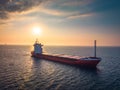 Sea sunrise over ocean horizon and sailing industrial cargo ship in deep blue open waters, aerial view Royalty Free Stock Photo