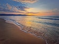 Sea sunrise scene, natural background. Early morning on the beach with a peaceful view to the dawn above the hills. Summer holiday Royalty Free Stock Photo