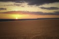 Sea sunset and brown field and orange clouds.