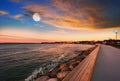 Sea sunset colorful evening sky and moon on cloudy  skyline,  light reflection on seawater, gold summer city  in   Tallinn old tow Royalty Free Stock Photo