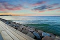 Sea sunset colorful sky ,skyline,  light reflection on seawater, seafront promenade and stones on beach,blue sky and pink fluffy c Royalty Free Stock Photo