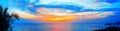 Sea sunset, ocean sunrise, tropical island beach dawn, palm tree leaves, blue water, colorful red pink orange yellow sky clouds Royalty Free Stock Photo