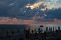 Sea sunset with silhouettes of people and beach umbrellas Royalty Free Stock Photo