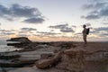 Sea sunset view. Man with backpack on rocks with beautiful view of Yeronisos Island near coast of Agios Georgios Pegeias Royalty Free Stock Photo