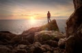 Sea sunset view. Man with backpack on the rocks Royalty Free Stock Photo