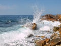 Sea surf. Splits waves against rocks in the sea