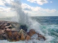 Sea surf. Splits waves against rocks in the sea