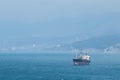 sea tanker, barge, ship in sea in distance, calm water, sunshine and sun, calm, seascape, in distance mountains and fog