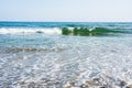 Sea tidal waves with white foam on a sunny sandy beach in resort Royalty Free Stock Photo