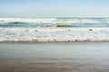 Sea tidal waves with white foam on a sunny sandy beach in resort Royalty Free Stock Photo