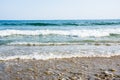 Sea tidal waves with white foam on a sunny sandy beach in resort Royalty Free Stock Photo