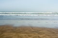 Sea tidal waves with white foam on a wet sunny sandy beach Royalty Free Stock Photo