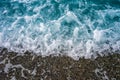 Sea tide on a pebble shore. Waves with white foam on a pebble beach. Nature concept, background