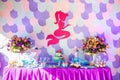 Sea time mermaid theme on the party`s candy bar with purple background. Birthday party for girls, teens