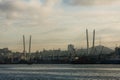 The sea trade port of Vladivostok on the background of the Golden Bridge across the Golden Horn Bay in the rays of the rising sun Royalty Free Stock Photo