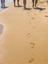 The sea transparent clear wave gradually washes away traces on the sand left by happy people having a rest. Royalty Free Stock Photo