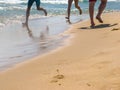 The sea transparent clear wave gradually washes away traces on the sand left by happy people Royalty Free Stock Photo