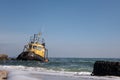 Sea tug sunken during a storm at the pier on a sunny autumn day