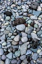 Sea tumbled round rocks on a beach with a few volcanic rocks mixed in, as a nature background