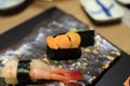 Sea urchin sushi wrapped in seaweed on a traditional Japanese dish in a Japanese restaurant. Royalty Free Stock Photo