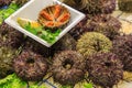 Sea urchins, exposed in plastic tray cut and whole in the Boqueria market Royalty Free Stock Photo