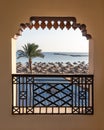 Sea view from the balcony at the beach with palm tree and umbrellas in Hurghada, Egypt Royalty Free Stock Photo