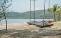 Sea view with lonely wooden swing on sandy beach. And Coconut t Royalty Free Stock Photo