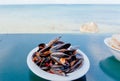 Sea view from outdoor restaurant with mussels ready for dinner. Seaside vacation with seafood Royalty Free Stock Photo